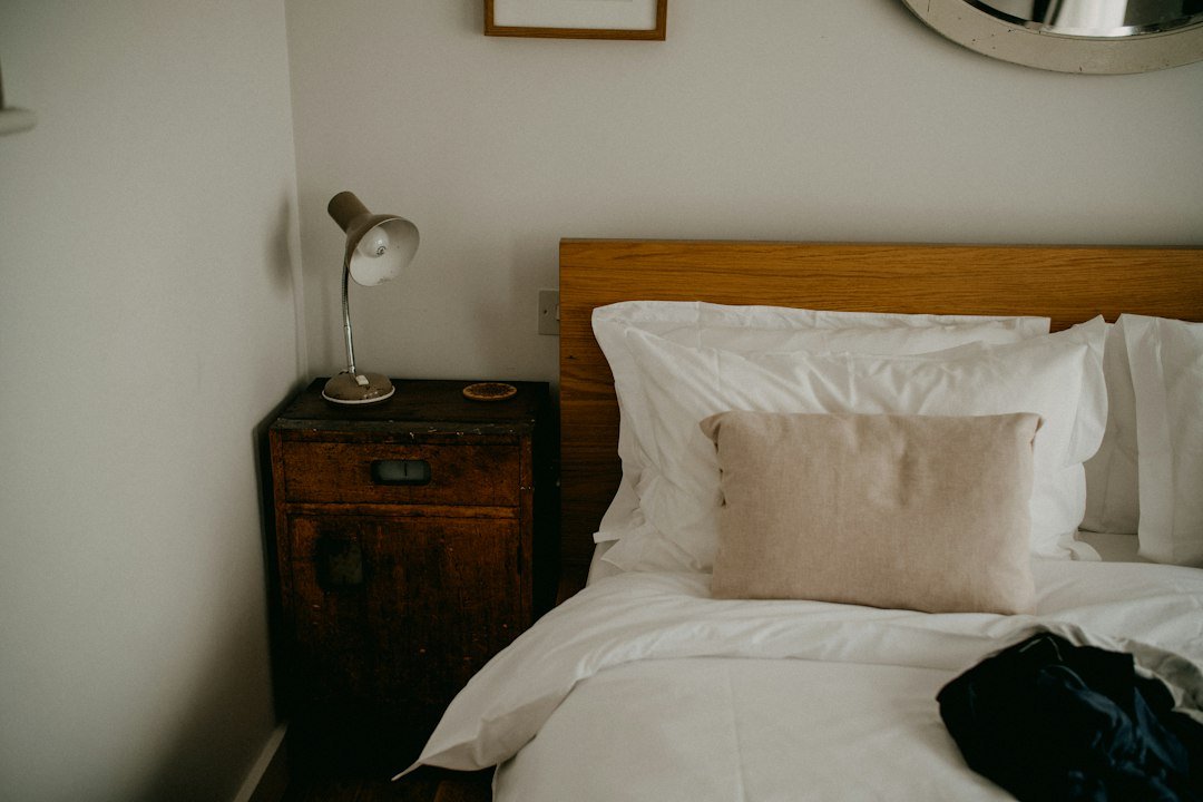 A cozy bedroom with a made bed and bedside table
