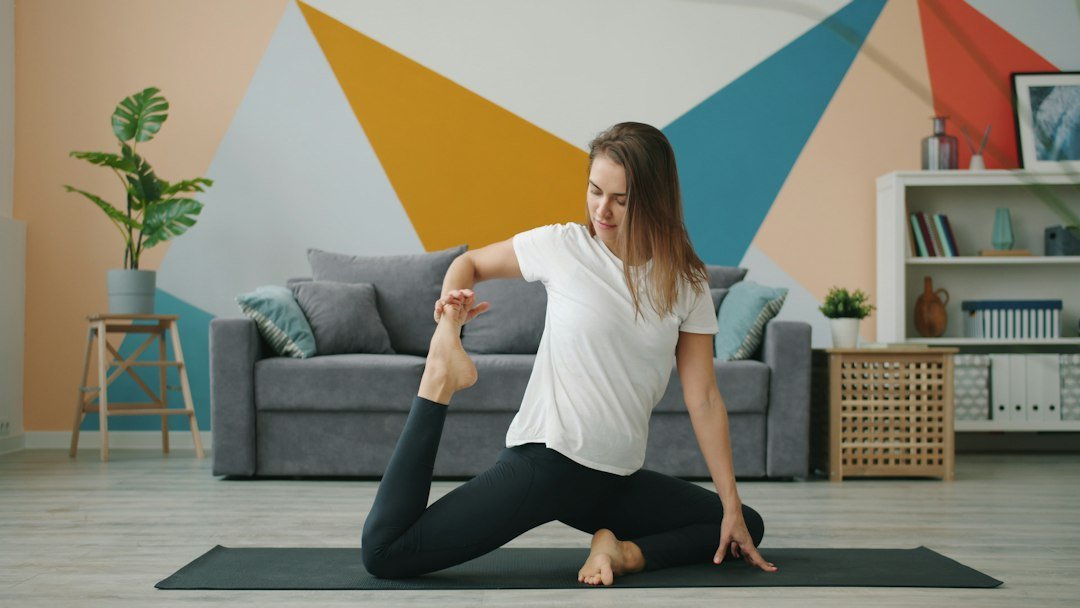 Woman practicing yoga on a mat in a living room