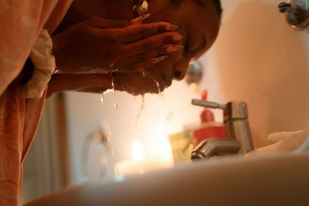 Woman washing her face at a sink
